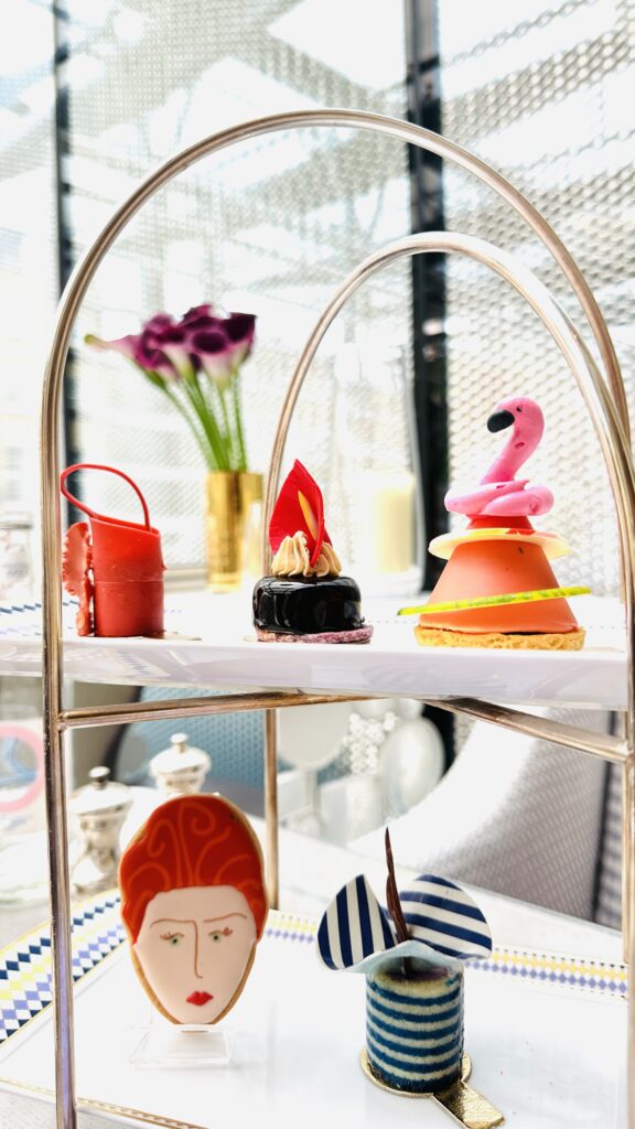 A tray of desserts on a table in front of a window.