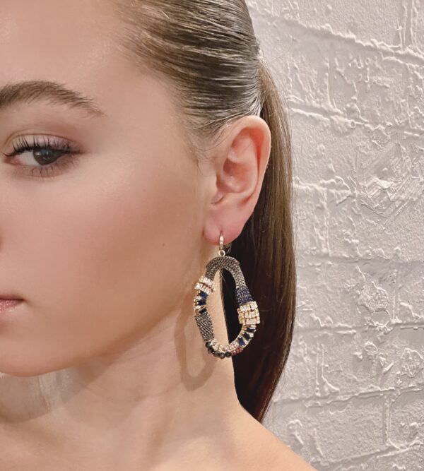 The model is wearing a pair of E5018 (Holiday) hoop earrings.