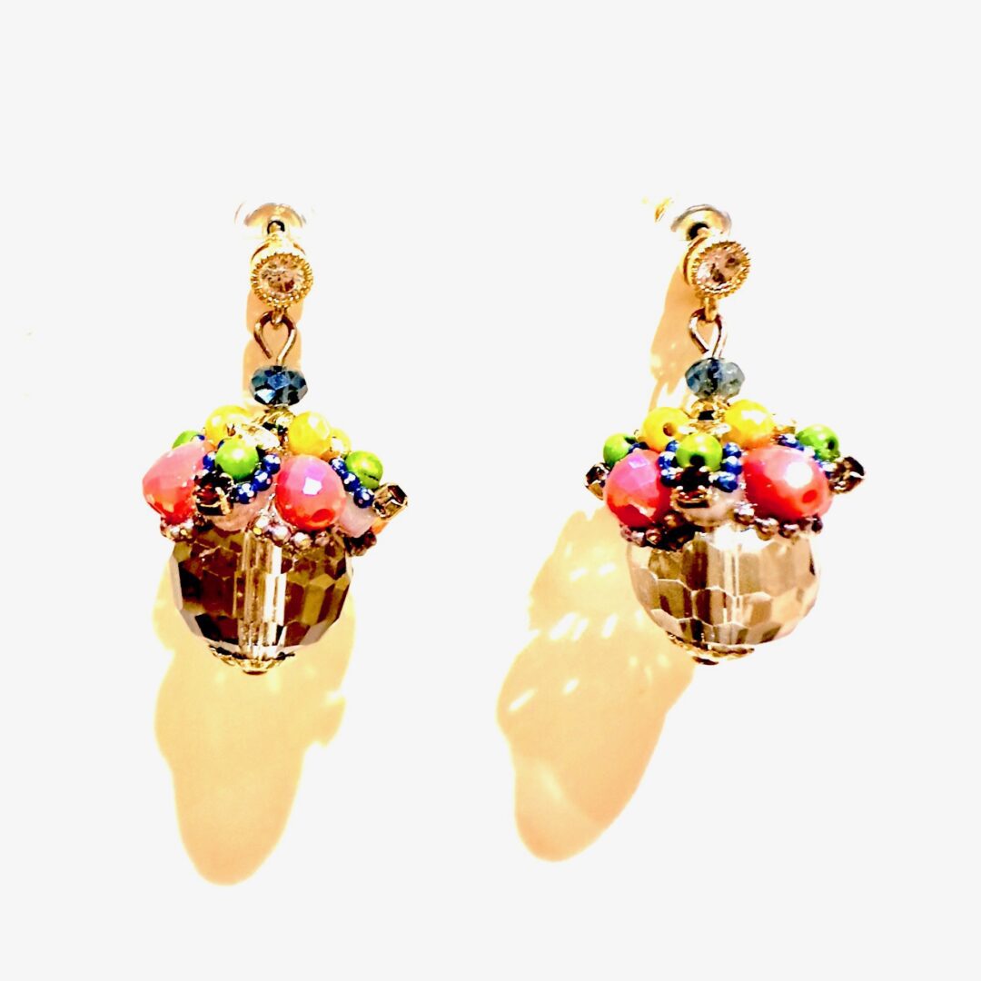 A pair of E5021 (Holiday) earrings with colorful beads on them.